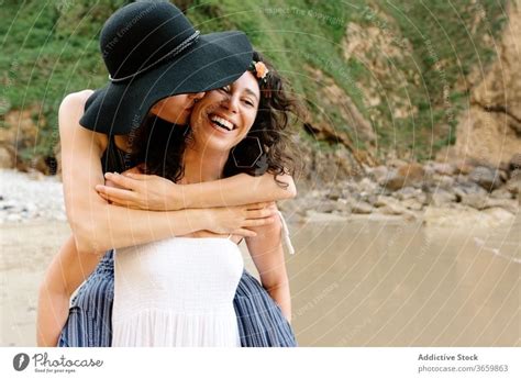 Lesbian Couple Embracing Near Ocean During Honeymoon In Summer A