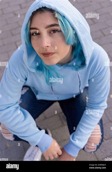 Blue Haired Teenage Girl In Light Blue Oversize Hoodie And Looking Into