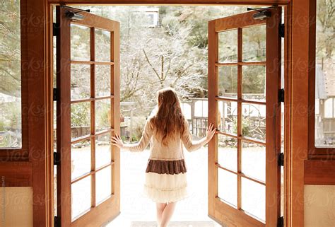 woman walking   opening doors     stocksy