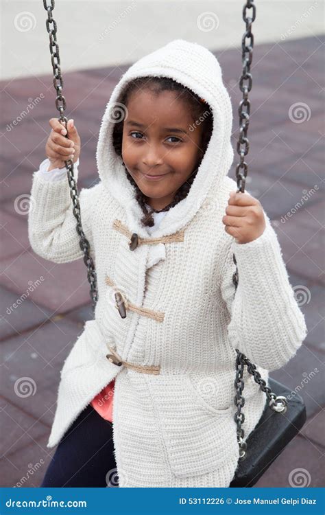 Outdoor Portrait Of A Cute Young Black Girl Playing With A Swing Stock