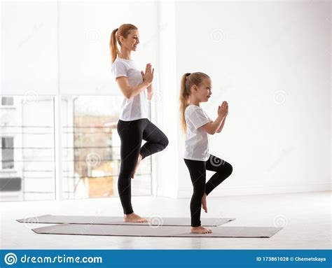 mother and daughter in matching sportswear doing yoga at