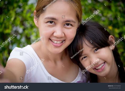 Asian Mother And Daughter Taking Selfie Photograph