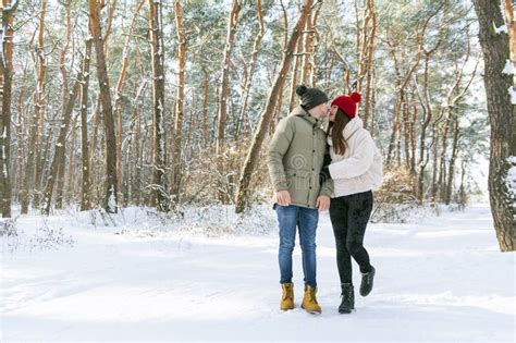 Young Couple Of Lovers Stands In The Winter Forest Looks At Each Other