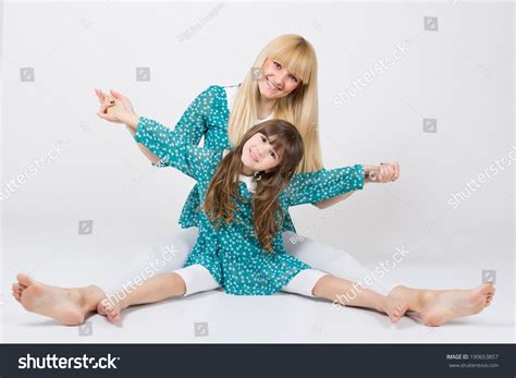 happy mother and daughter sitting on the floor wearing matching outfit