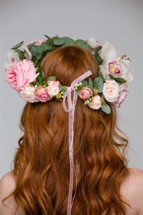 back view of woman with long hair in flower wreath stock