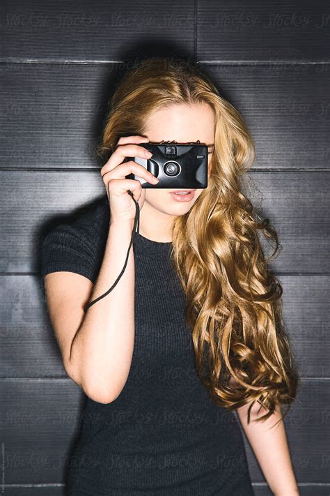 Close Up Of Blondie With Curly Hair Taking Photo With Old Film Camera