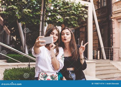 Two Funny Girls Take A Selfie Friends Take A Selfie On A City Street