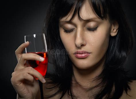beautiful woman crying with a glass of red wine stock