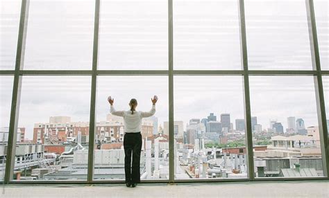 businesswoman   window  office building   city  hands raise