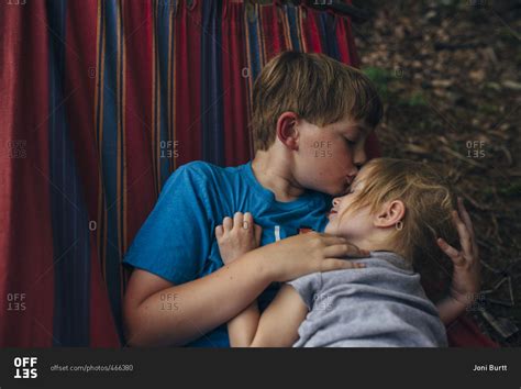 Brother Kissing His Sister S Forehead As They Cuddle In A