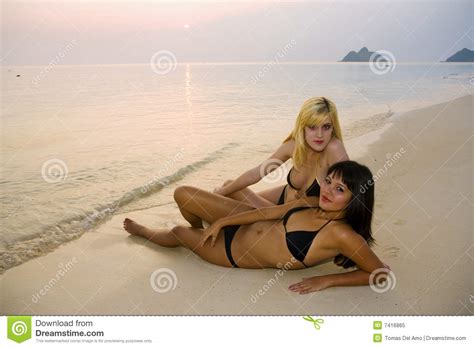 two female friends in bikinis at the beach royalty free
