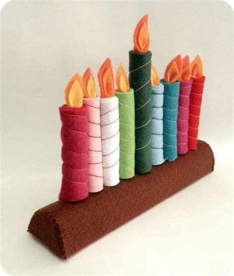 row  multicolored candles sitting  top   piece  felt