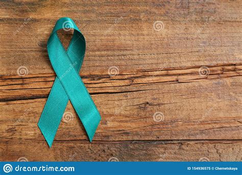 teal awareness ribbon  wooden background top view  space