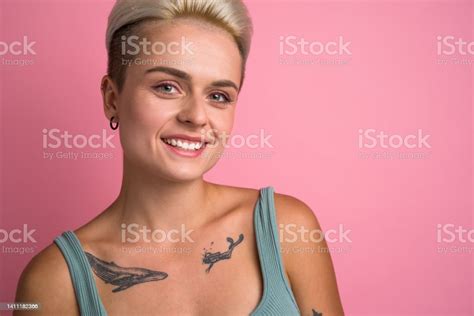 Short Haired Blonde Woman With Tattoos Looking Straight To The Camera