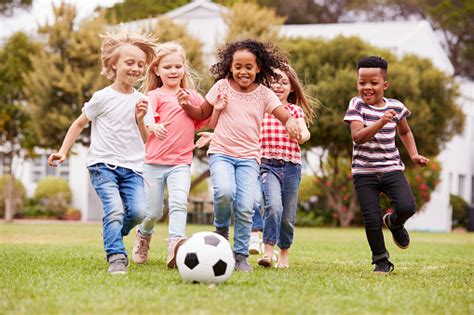 group  children playing football  friends  park stock photo