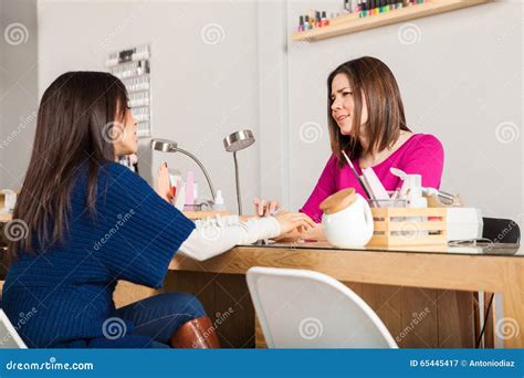 manicurist  client talking   nail salon stock image image