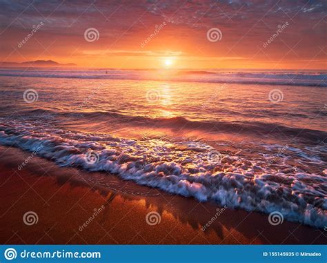 Beautiful Red Sunset On Beach With A Wave Stock Image