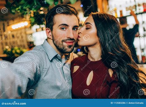 een andere selfie van paar het meisje kust haar partner terwijl hij een beeld neemt zij kijken