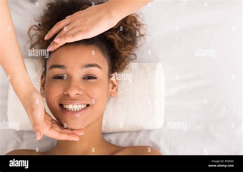 African American Woman Enjoying Face Massage At Beauty Salon Stock