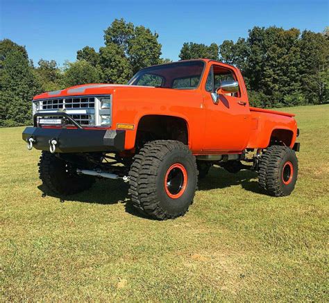 orange truck parked  top   grass covered field