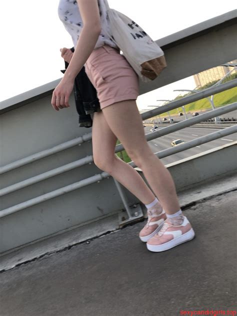 cute teen in mini shorts walking on the bridge street