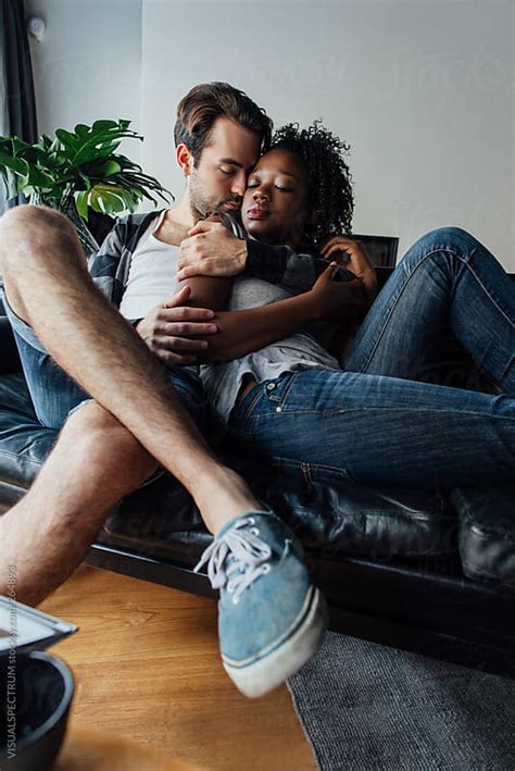 mixed race couple cuddling by visualspectrum stocksy united