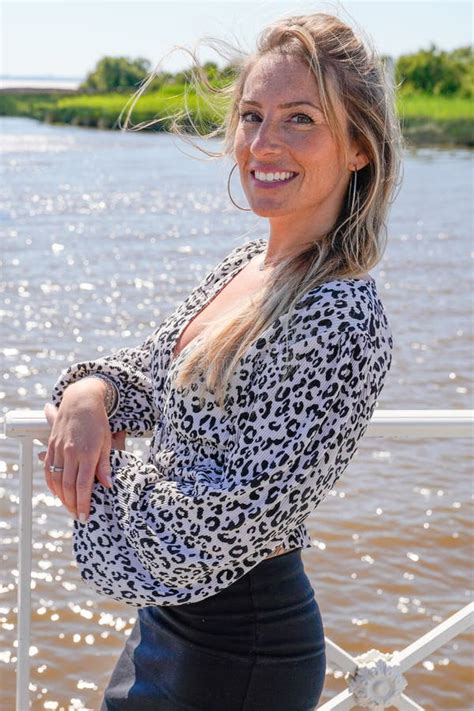beautiful blonde woman smiling enjoying vacation on harbour beach stock