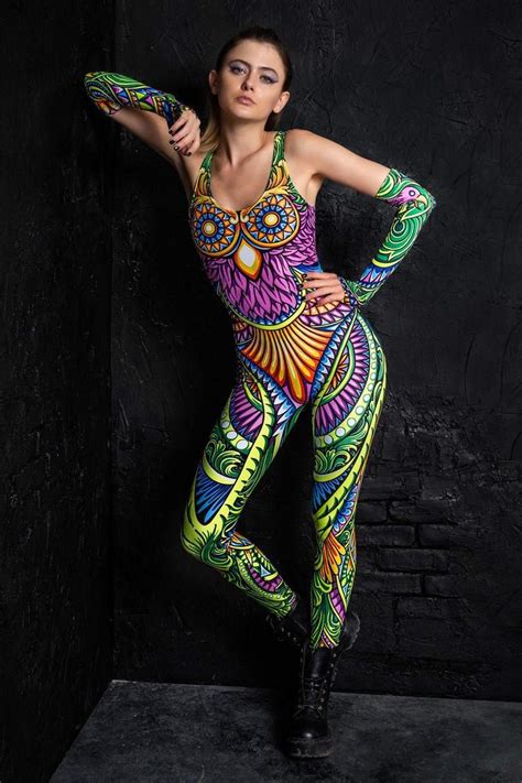 A Woman In Colorful Bodysuit Posing With Her Hands On Her Hips And Arms