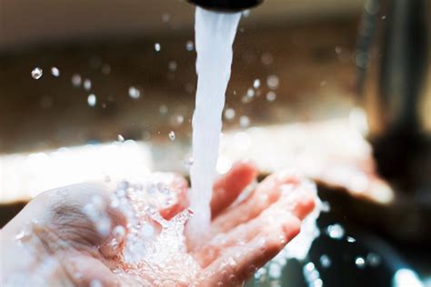 person holding water drop  water photo  washing image  unsplash