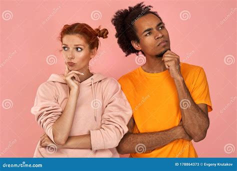 Thoughtful Ginger Woman And Dark Skinned Man Do Not Look At Each Other