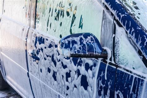 Car Wash A Person At A Self Service Car Wash Under A Stream Of