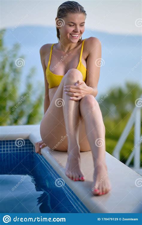 elegant woman in bikini on the sun tanned slim and shapely body is