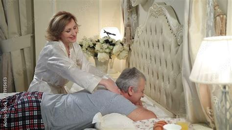 mature woman giving massage to senior man in bed stock video adobe stock