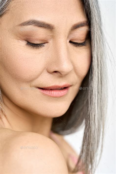 Closeup Of Asian Mature Woman Looking At Her Skin After Spa Stock