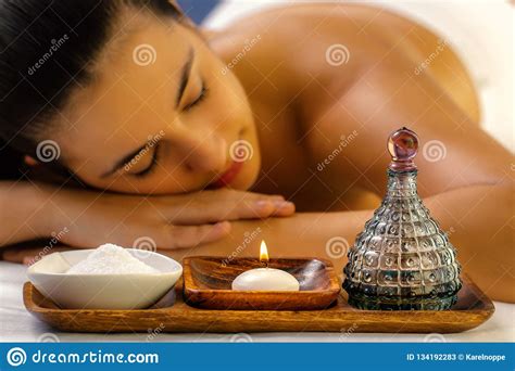 massage oil and candle with out of focus girl in background stock image