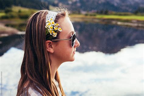 side view of a teen girl in glasses with flowers behind her ear by