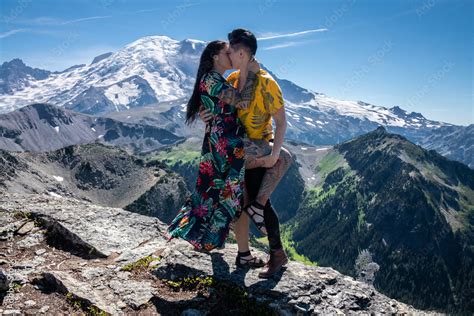 zdjęcie stock view of lesbian couple kissing in front of mount rainier