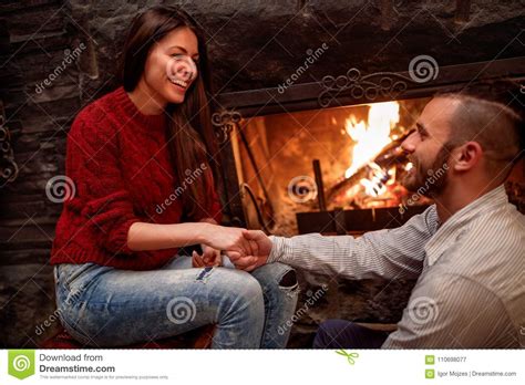 Romantic Couple Sitting On The Floor In Front Of Fireplace