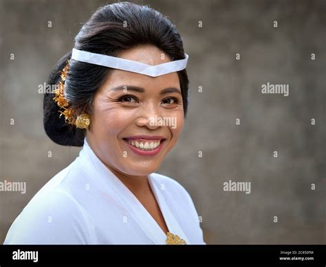 Mature Indonesian Balinese Woman Wears White Clothes And Smiles For The