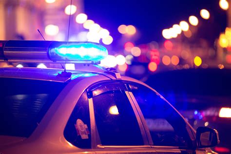 blue light flasher atop   police car city lights   background  bail reform news