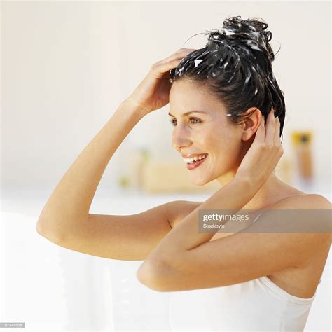 side view of a woman scrubbing her hair photo getty images