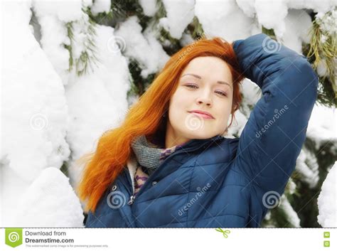 happy beautiful redhead girl relaxes in snowy pine forest stock image
