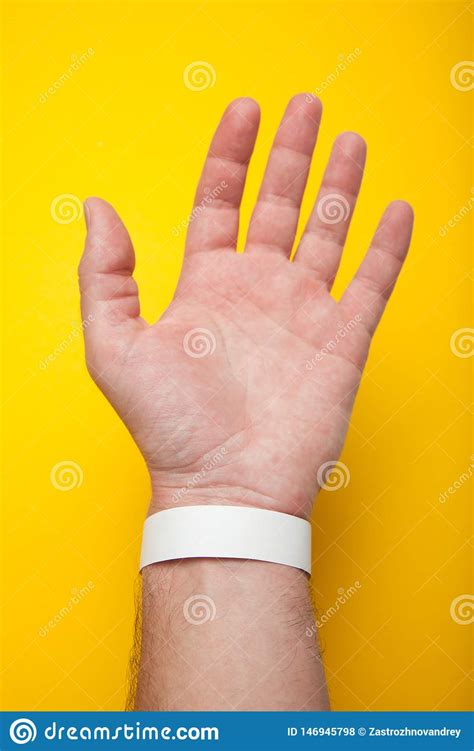 blank mockup bracelet  hand isolated  yellow background concert paper wristband stock