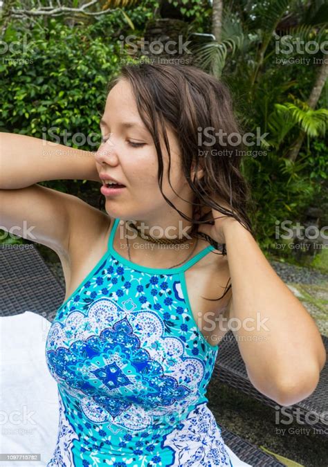 緑の木々 と熱帯の場所でポーズをとってブルー水着で美しいブルネットの少女長い髪のフルレングスと完璧なセクシーな体とビキニの若いスポーツ モデル