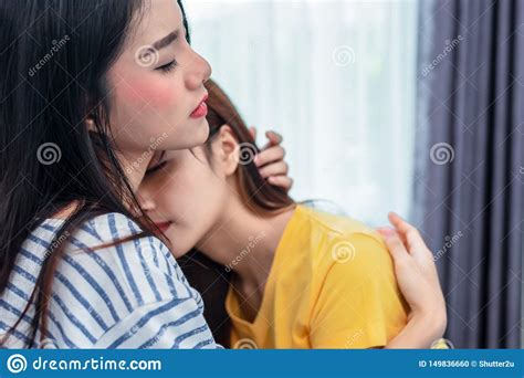 close up of two asian lesbian women embracing together in bedroom