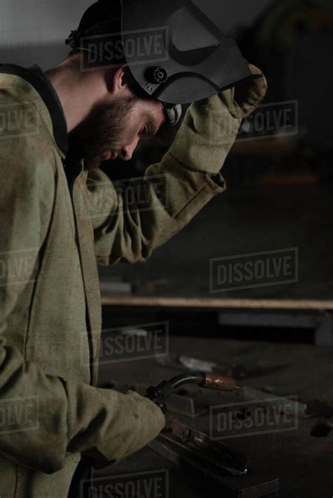 side view  welder lifting  protective mask     work stock photo dissolve