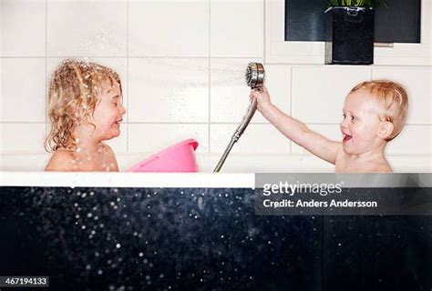 brother and sister taking a bath together photos et images de