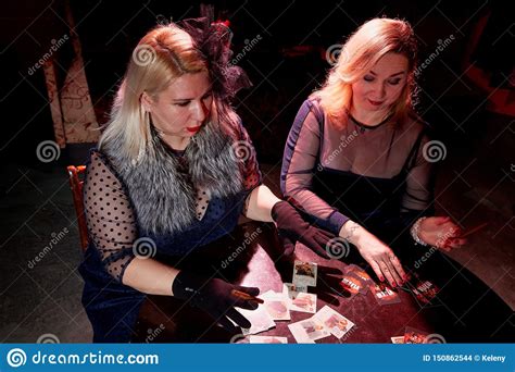 due donne grasse con le carte da gioco in una stanza scura