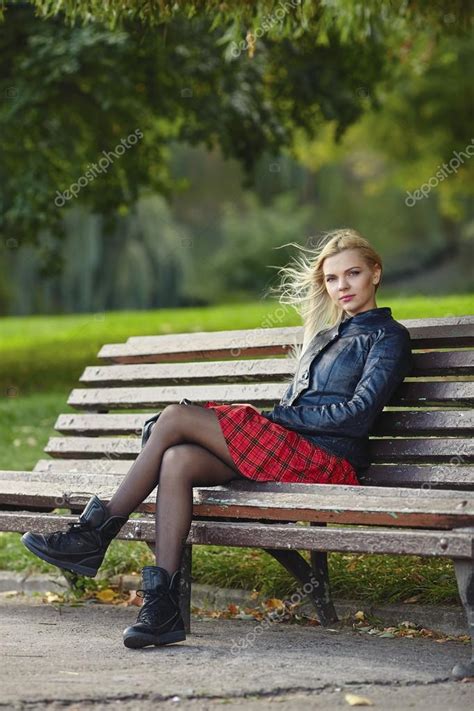 Крупным планом на открытом воздухе Портрет молодой очаровательны блондинке сидя на скамейке в