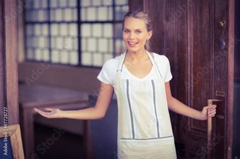smiling blonde waitress welcoming acheter cette photo libre de droit